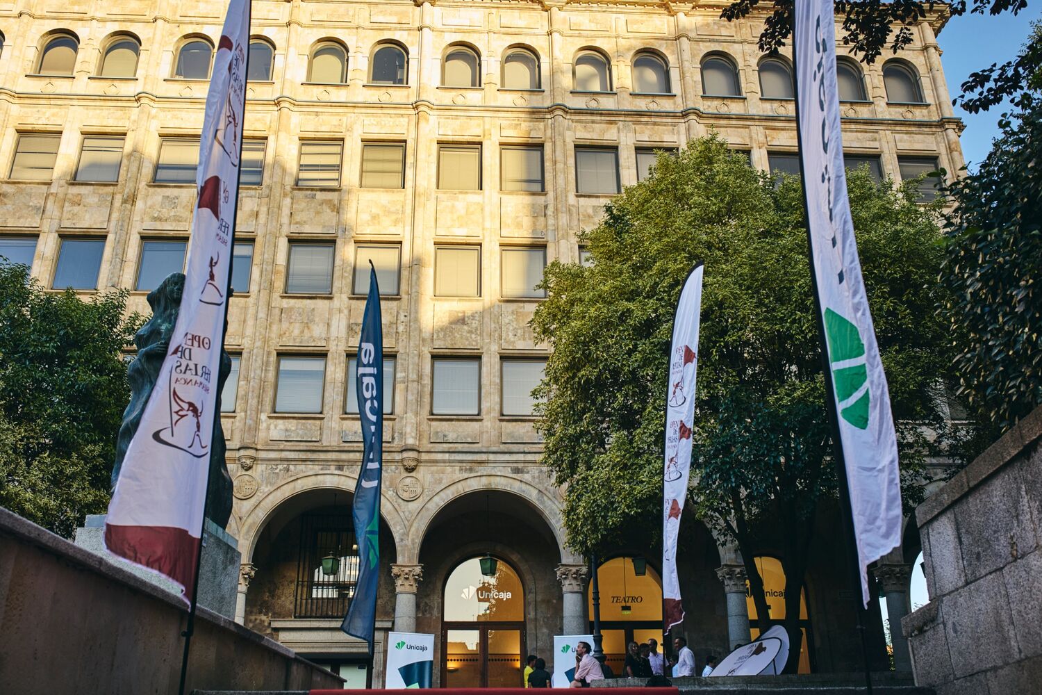 Banderolas del torneo frente a la fachada de piedra del Teatro Unicaja